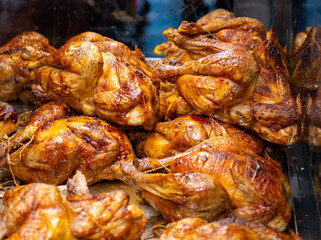 Whole chickens roasted on wooden charcoal barbecue grill