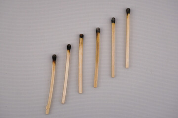 This is a close up picture of matches that have been burned, lined up in a row, to create and interesting pattern and background.
