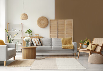 Interior of light living room with grey sofas, wooden armchair and coffee table
