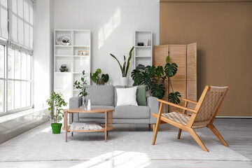 Interior of bright living room with coffee table, cozy sofa and armchair