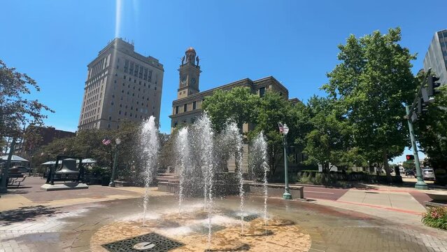 A wide tilt up view of the Stark County Courthouse and clock tower in downtown Canton, Ohio on a sunny summer day.  	