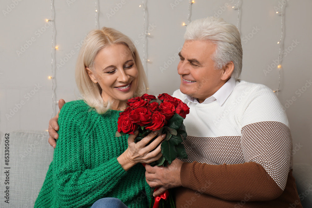 Canvas Prints Happy mature couple with bouquet of roses at home