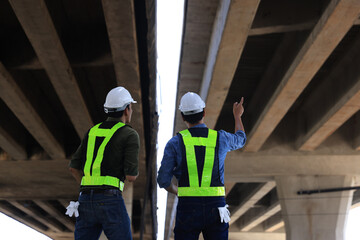 Two civil engineers working on the Structure road construction of the expressway under construction. New road construction. Civil Engineer.