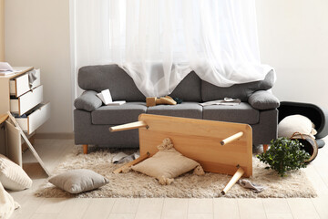 Interior of living room with messed furniture after earthquake