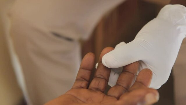 A healthcare worker pricking a finger for blood testing for HIV positivity. Shot in Uganda on 25 April 2017.