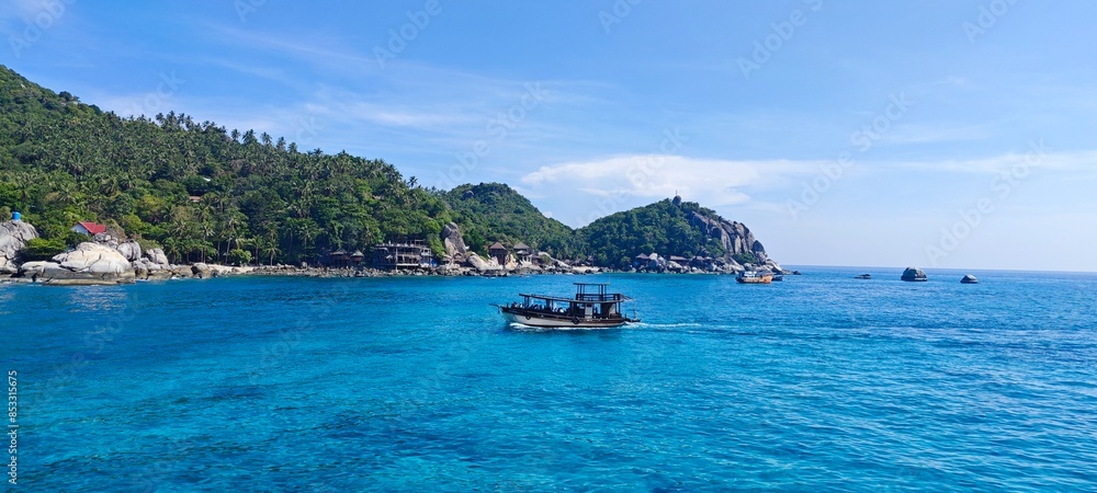 Wall mural tropical island with crystal clear water and a boat