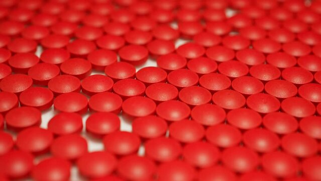 Medical pills factory, pharma industry and manufacturing concepts. Slow rotation of red pills. National Opioid Awareness Day.