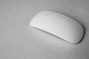 One wireless mouse on light textured table, closeup. Space for text