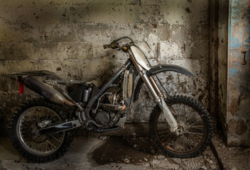 old broken motorcycle in old cement barn