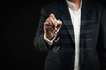 Businessman using a pen to tick the correct sign mark on a virtual screen checklist.