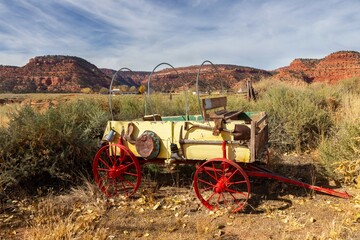 Vintage Wild West Horsedrawn Pioneer Wagon Wheel Cart Relic Model.  American Southwest Western Prairie Mountains Landscape Background, Utah USA