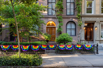 Townhouses in Chelsea Historic District in summer with rainbow flag decor in celebration of LGBTQ+ Pride Month. Manhattan, New York City