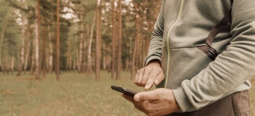 Person using mobile phone in forest 