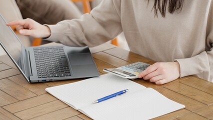 インターネットで費用を調べて計算する女性