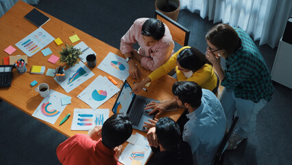 Top down view of multicultural business group putting hand together to celebrate increasing sales...