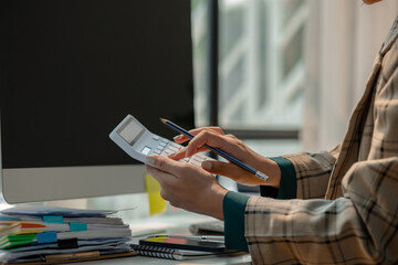 working in workplace on the desk with computer, female employee is looking on document, en entrepreneur is trying so hard to build startup company, finance department