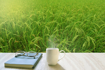 On a gray wood floor, cups, white coffee place, diary and glasses.
The front saw the rice plant  is growing. (Paddy mild)
Feelings, sadness, loneliness, nostalgia