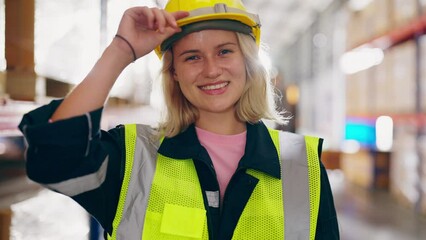 Young woman happy standing and looking at camera. Female warehouse worker smiley and smart confident at storehouse