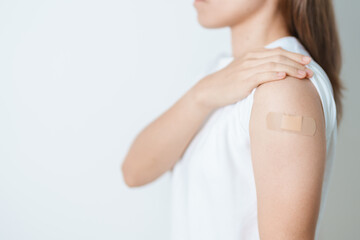 Woman with bandage after receiving vaccine. Vaccination and Immunization for Influenza, HPV, Zoster, IPD, DTP or Diphtheria, Tetanus and Pertussis, MMR, Hepatitis B, Covid  and Varicella vaccine