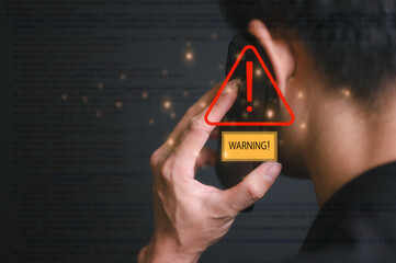 risk and cyber security technology concept man holding mobile phone with alert warning triangle...