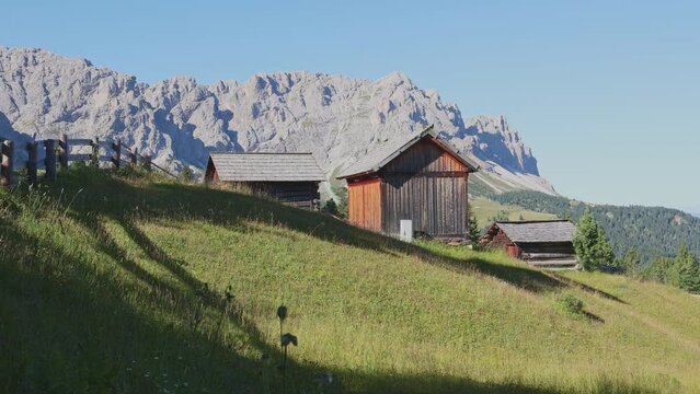 Rare houses and outbuildings on hillsides in Mont-de-Fornel region, Dolomites.