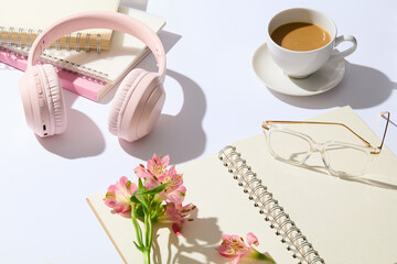 Advertising banner template with essential supplies of office featured on the white table, decorated with some pink flower and a cup of morning coffee. Photo from above view with copy space for text