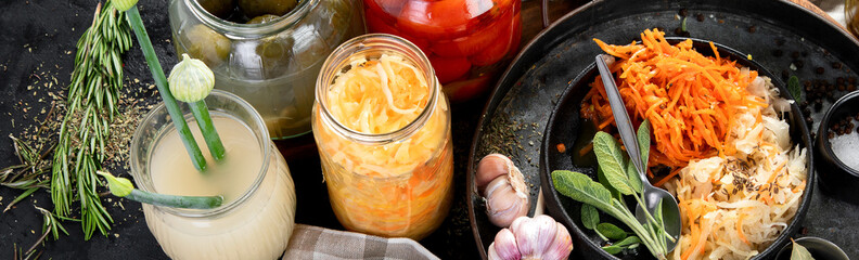 Fermented products on a dark background. Pickled vegetables in jars