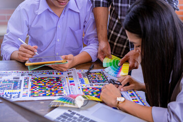 Worker checking print quality of media graphics proof print and color tone in printing industry....