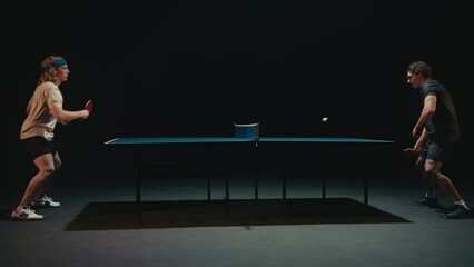 Table Tennis Players in a Match in a dark room