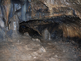 Hiking Inside the Dark cave environment with mineral deposits on the floor and walls
