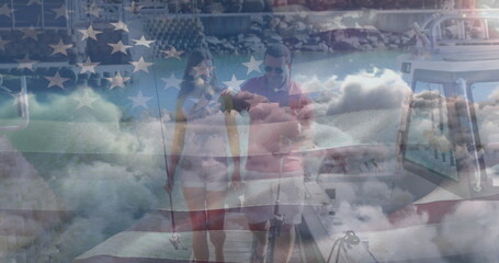 Independence text and waving american flag over couple with fishing rods on a boat against clouds