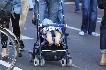 Obraz premium Man strolling a baby on a crowded street