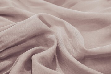 Close-up of pale pinkish fabric with soft folds and texture