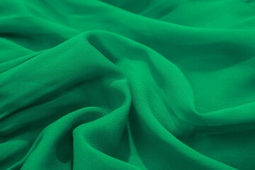 Close-up of green fabric with soft folds and texture