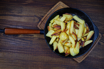 Roasted potatoes. Potatoes fried in butter in a cast iron frying pan.