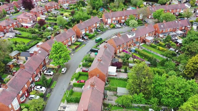 Aerial footage of the City of Wakefield in West Yorkshire UK, showing a typical British housing estates with roads and streets, taken with a drone on a sunny day in the summer time above the houses.
