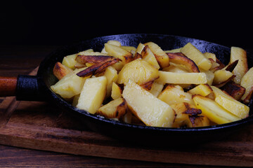 Roasted potatoes. Potatoes fried in butter in a cast iron frying pan.