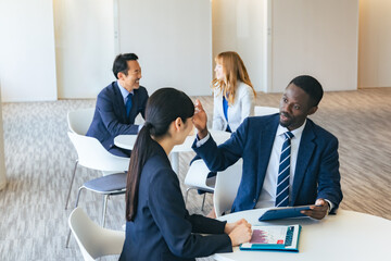 ロビーで会話する多国籍ビジネスパーソンのグループ