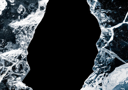 Hole, broken in a pure transparent crushed ice with cracks on a black background, close-up.