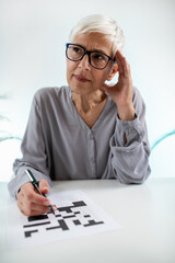 Cognitive rehabilitation therapy for a senior woman through crossword puzzles, promoting mental...