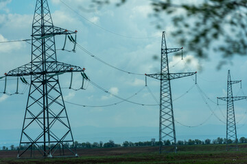 High voltage towers with sky background. Power line support with wires for electricity transmission. High voltage grid tower with wire cable at distribution station. Energy industry, energy saving