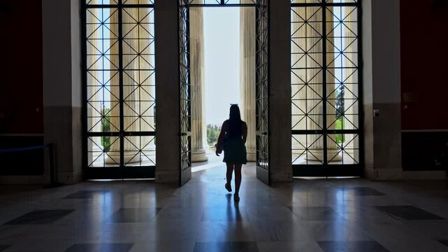 Silhouetted female exiting Zappeion Hall, smooth slo-mo follow-shot
