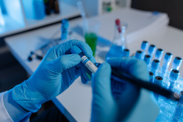 A scientist uses laboratory equipment for a research experiment, test tube is essential for chemists to use in experiments, scientific researchers must concentrate on testing samples in the lab