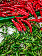 Pile of Red Chili Peppers and Green Bird's Eye Chili Peppers at a Traditional Market