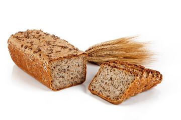 Freshly baked bread on wooden cutting board with ears of wheat.