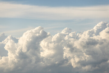 The sky is filled with fluffy white clouds, creating a serene and peaceful atmosphere. The clouds...