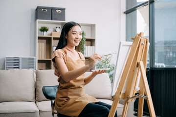 sian Female painter do artwork in art workshop, painting supplies, oil pastels, two canvas easel, creative space