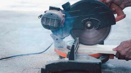a circular saw in action, cutting through a piece of wood. The image captures the motion and precision of the tool, symbolizing carpentry, woodworking, and craftsmanship