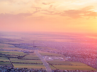 Aerial view of a vivid sunset over the city. Panorama of streets and buildings. Vibrant color cityscape. 