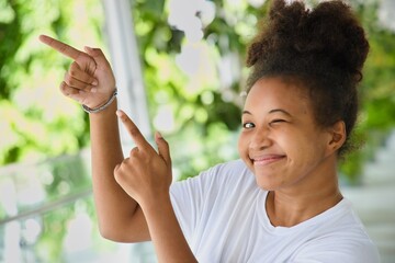 Young African young woman showing, presenting by pointing up her finger up